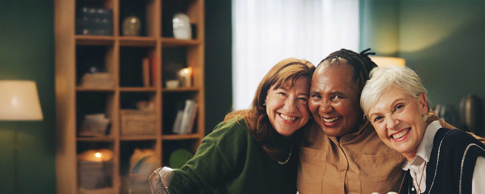 A group of senior women sharing a warm embrace while posing for a photograph.